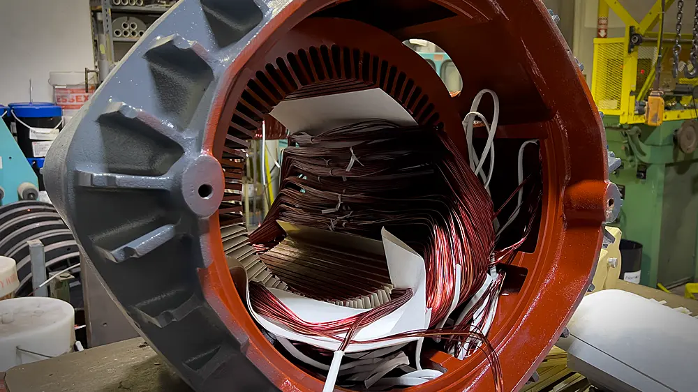 Rewinding electric motor with copper wire.